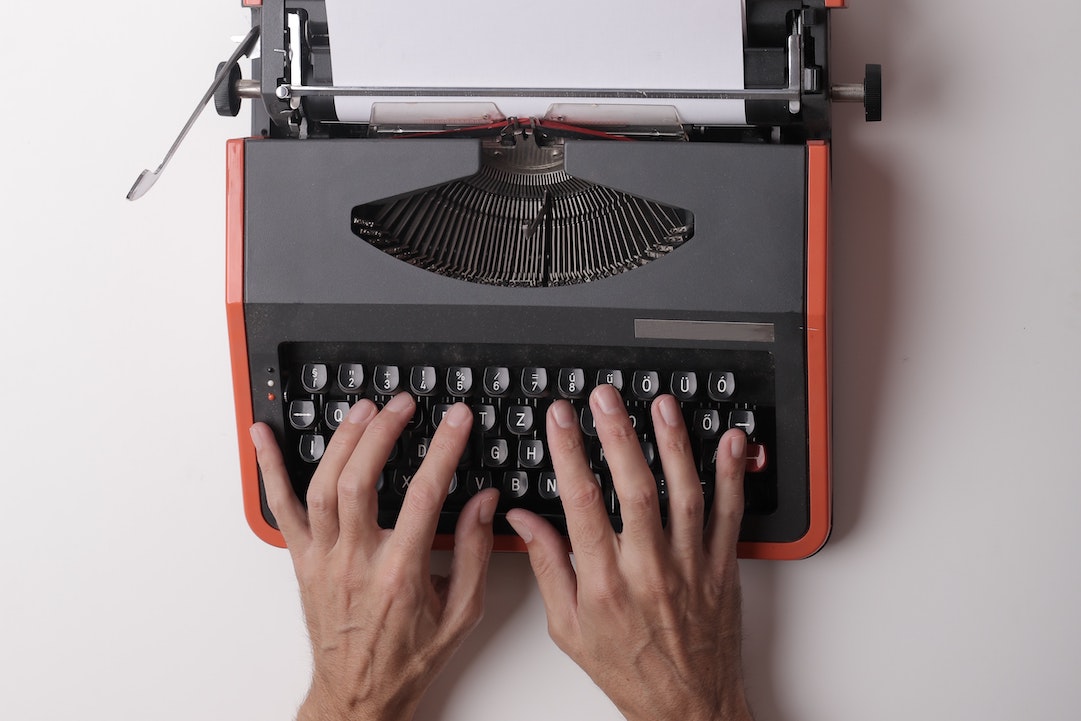 Contenuto dell'e-mail - mani su una macchina da scrivere rossa - Foto di Andrea Piacquadio - Pexels