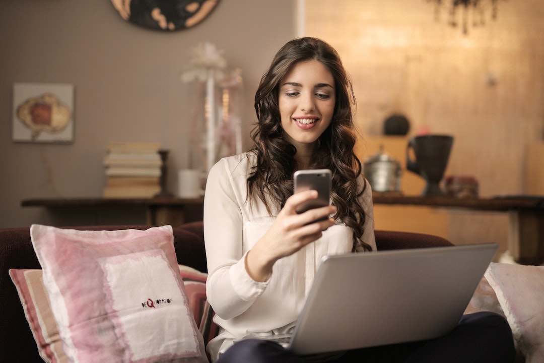 Immagine di una donna che sorride guardando il suo telefono - foto di Andrea Piaquadio - Pexels