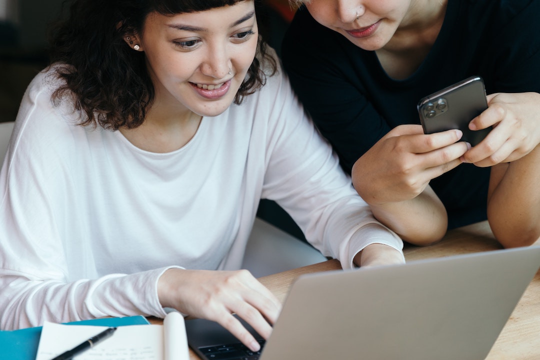 Donne davanti a un computer con un cellulare - Foto di Ketut Subiyanto - Pexels