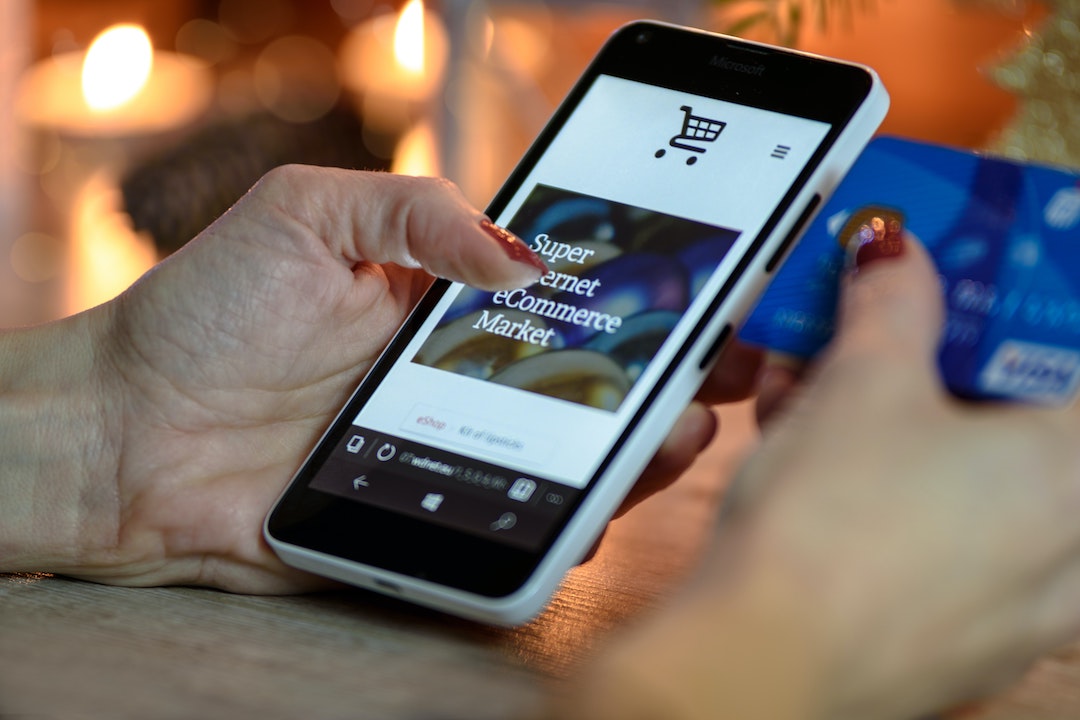Un pollice su un sito di e-commerce visualizzato sul cellulare - email di vendita convincenti