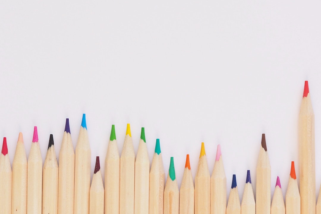 Una fila di matite colorate su sfondo bianco - Foto di Jess Bailey Designs - Pexels